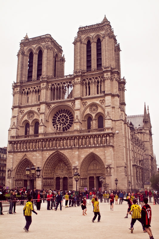 Kids playing soccer outside of Notre Dame Cathedral